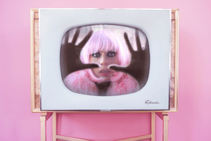 Map of the Heart pink heart perfume V.6 lookbook imagery - woman in pink wig inside a tv